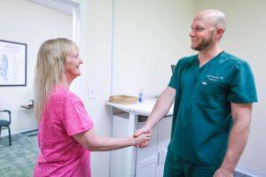 Chiropractor smiling with elderly patient