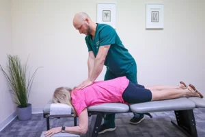 Chiropractor adjusting young girl on treatment table