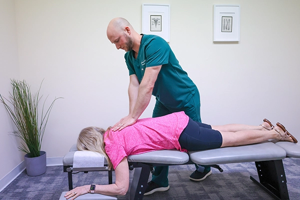 Chiropractor adjusting young girl on treatment table