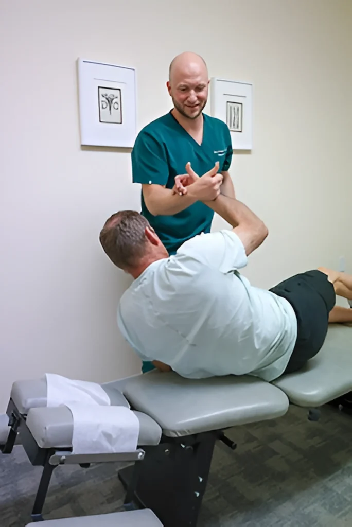 Chiropractor performing adjustment using specialized chiropractic table