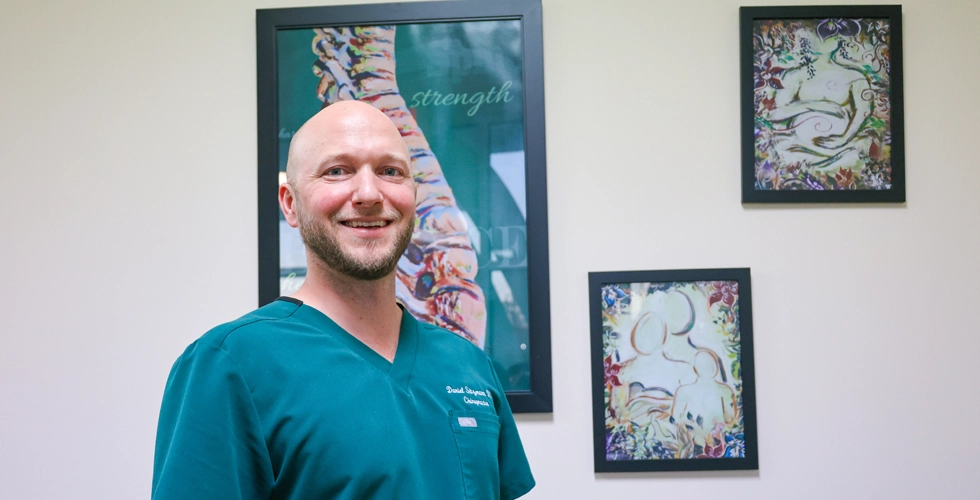 Dr. Daniel Sitzmann smiling inside his chiropractic office in Lincolnton NC