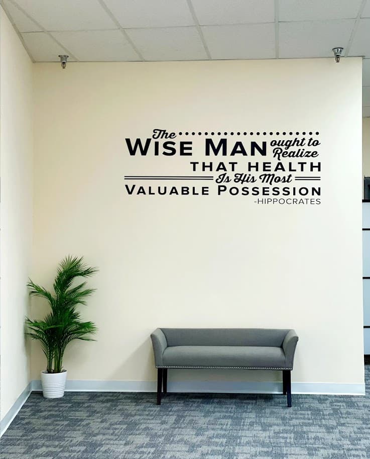 Chiropractic clinic seating area with wall message