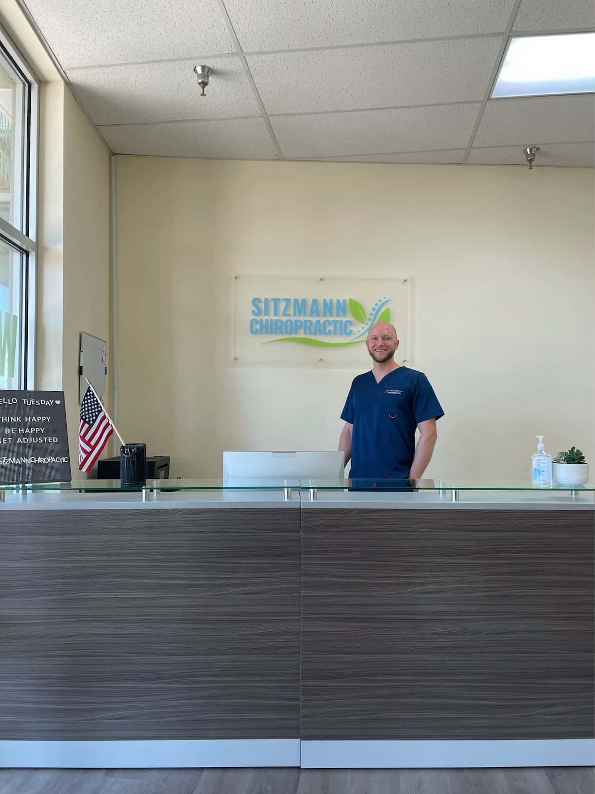 Chiropractor standing behind reception desk
