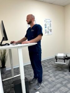 Wide view of chiropractor working at desk