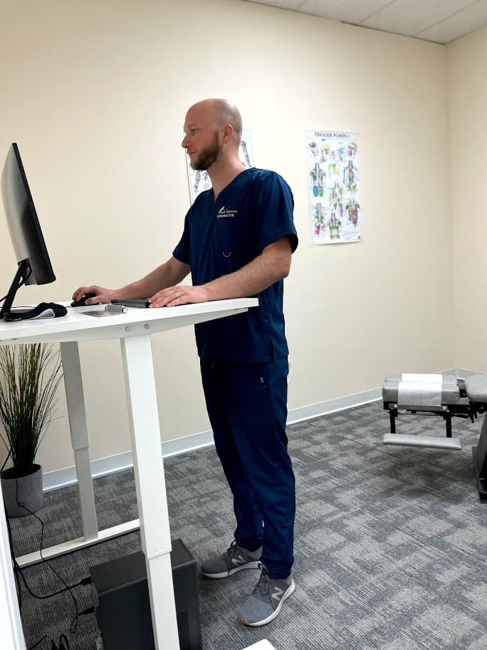 Wide view of chiropractor working at desk