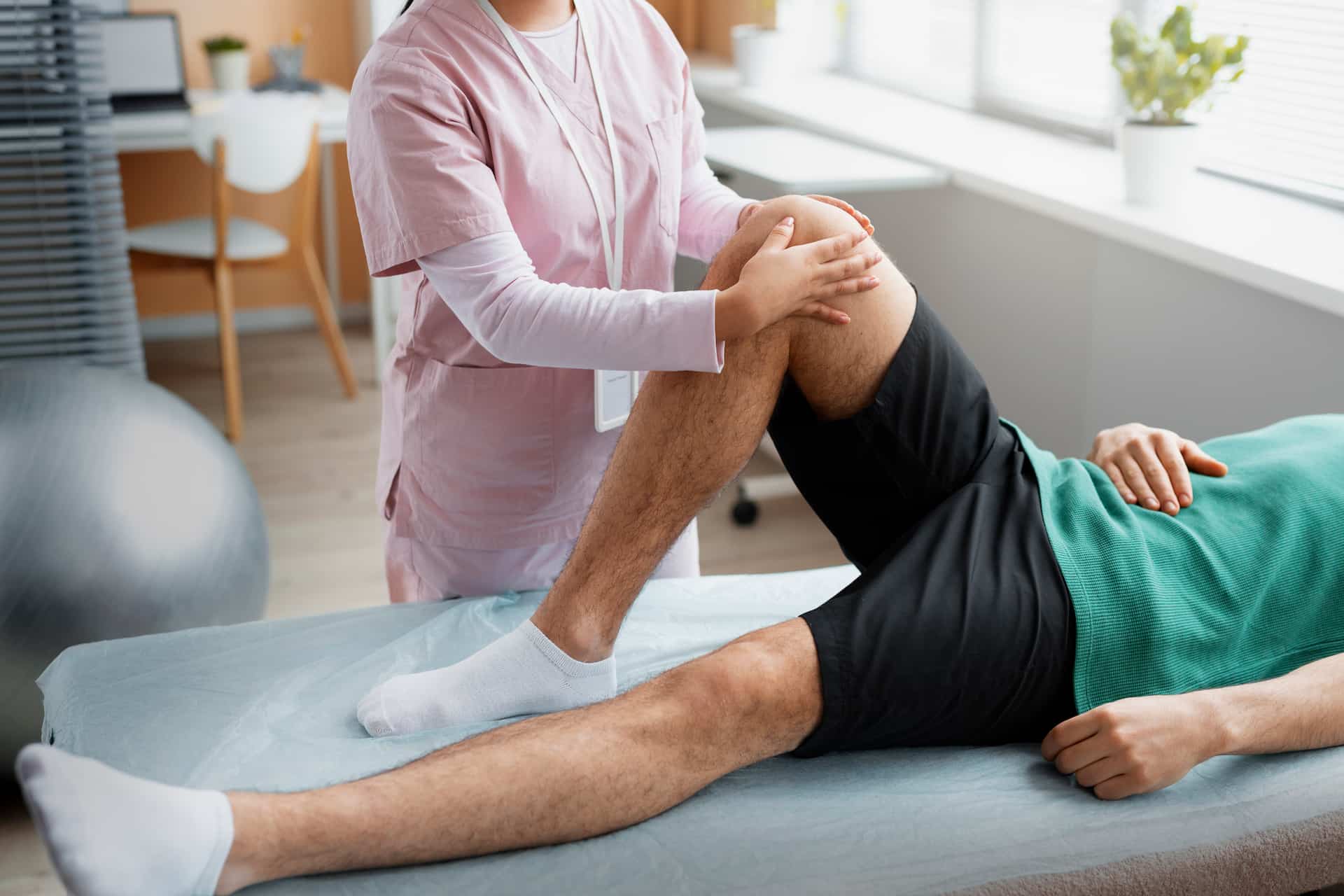 Chiropractor providing hands-on manual therapy to a patient's leg and knee to alleviate chronic joint pain and inflammation