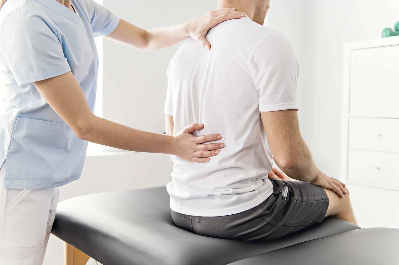 Chiropractic professional assessing patient’s spine and lower back pain during in-clinic consultation