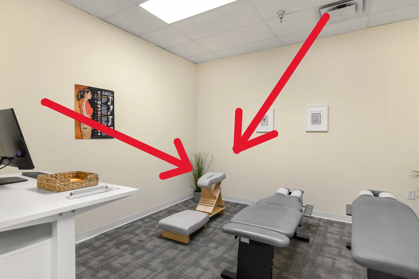 A chiropractic room with two adjustment tables, a knee chest pregnancy specific adjustment table, a desk with a computer, and a spinal anatomy poster.